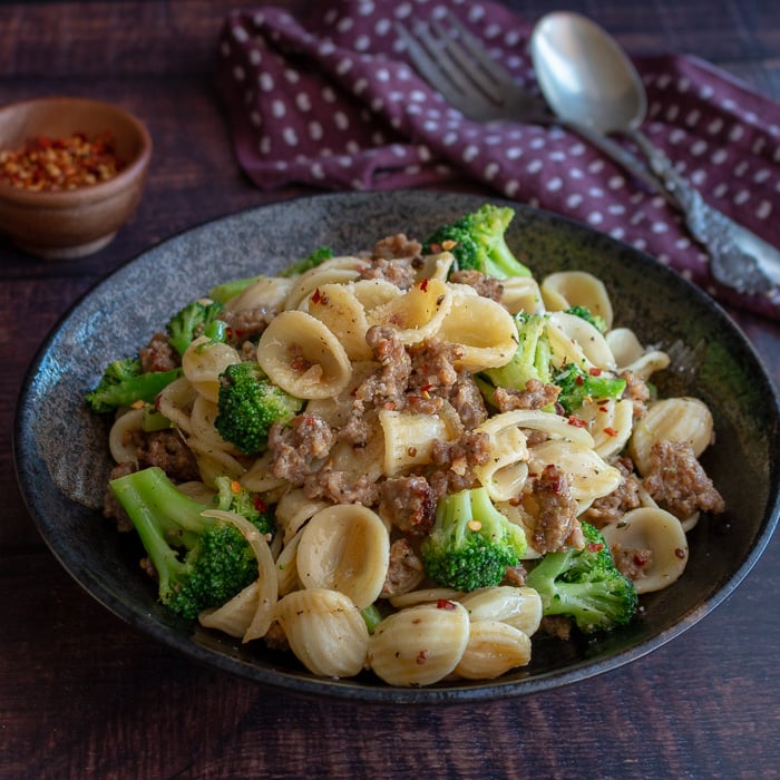 Orecchiette and Chicken Sausage in a Garlic Wine Sauce in a black bowl