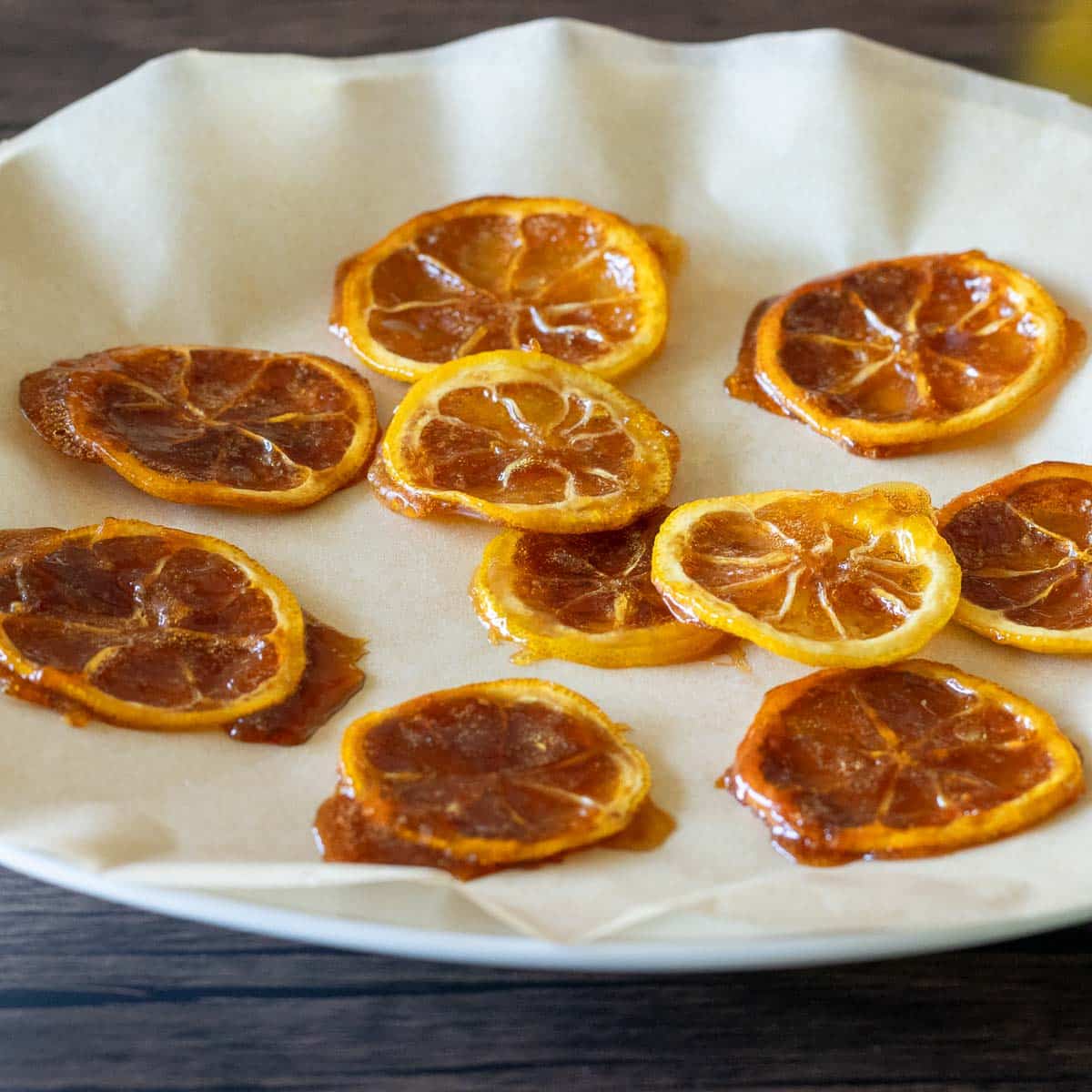 Lemon slices cooling on greased parment paper lined dish.