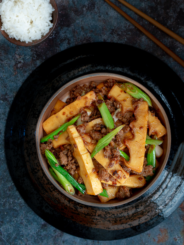 Top down shot of spicy pork and bamboo with rice and chopsticks. 