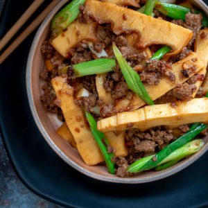 top down photo of stir fried spicy pork and fresh bamboo shoots with chopsticks