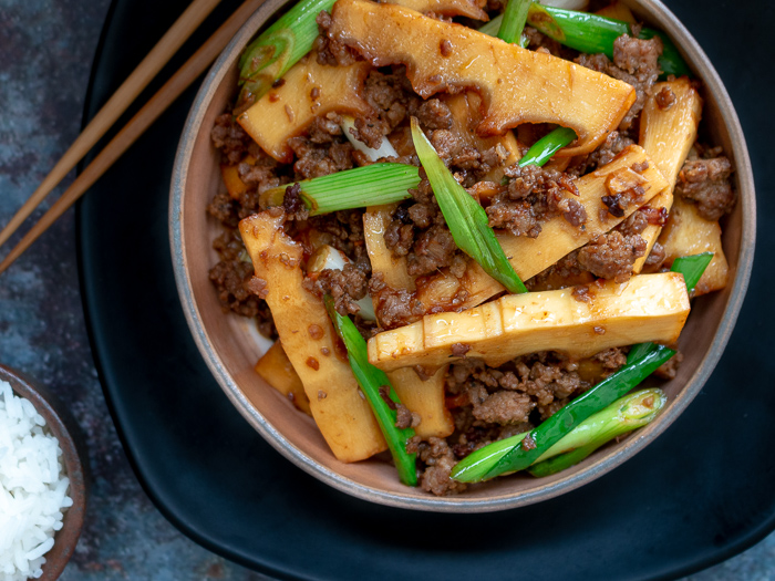 top down photo of stir fried spicy pork and fresh bamboo shoots with chopsticks