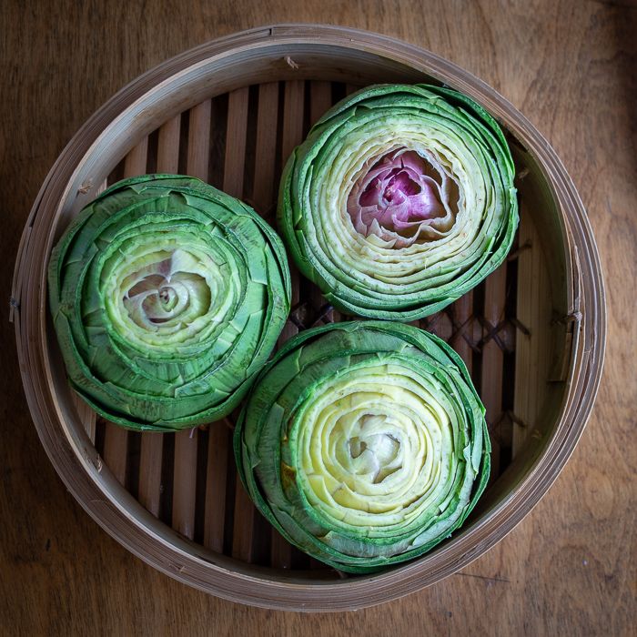 3 artichokes cleaned and in a bamboo steamer basket.