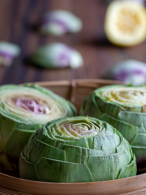 Artichokes prepped and ready in a bamboo steaming basket.