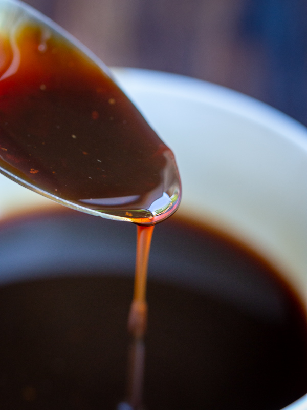 Date paste thinned with a little hot water and showing the pour from a spoon.