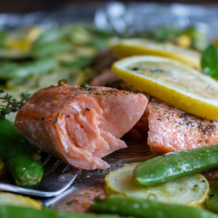 The bite shot! Flaky trout fish on a fork with a drizzle of lemon. 