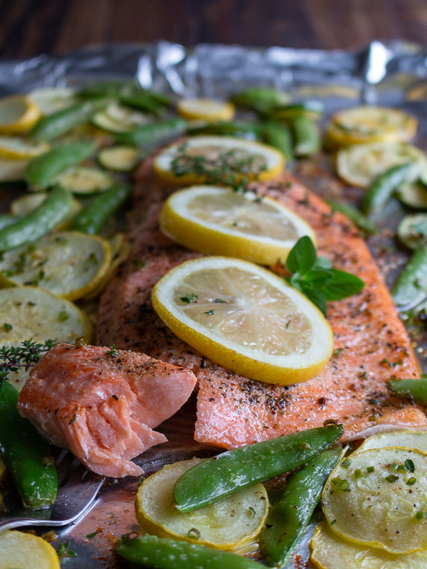 Bite shot with the full tray of whole trout fillet. Closeup of herbs and lemons and super flaky fish and moist.