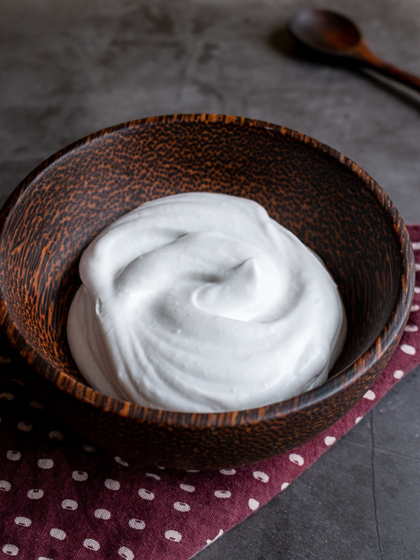 Homemade Coconut Whipped Cream in a brown wooden bowl.