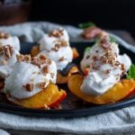 Grilled Nectarines with a dollop of whipped coconut cream and crushed candied nuts on each.