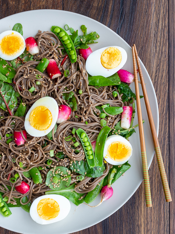 Large plate of soba noodle salad showing only half the plate with chopsticks on the side.