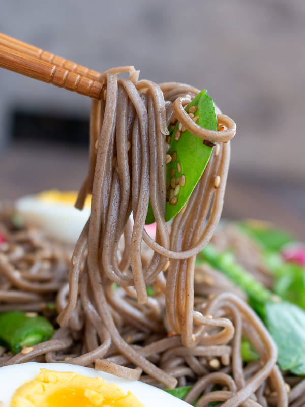 The bite shot! Chopsticks picking up a delightful bite of soba noodle salad. 