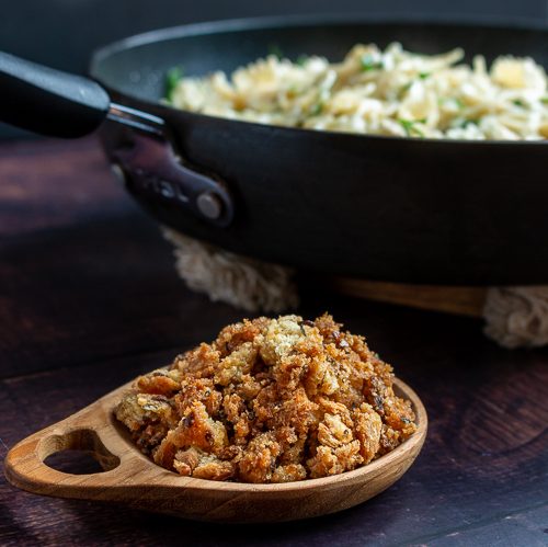 Bowl of homemade Bread Crumbs Next to a skillet of freshly made pasta.
