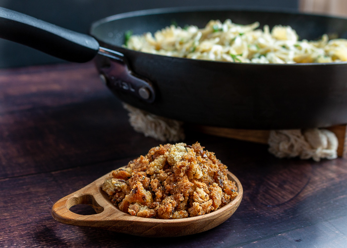 Bowl of homemade Bread Crumbs Next to a skillet of freshly made pasta.