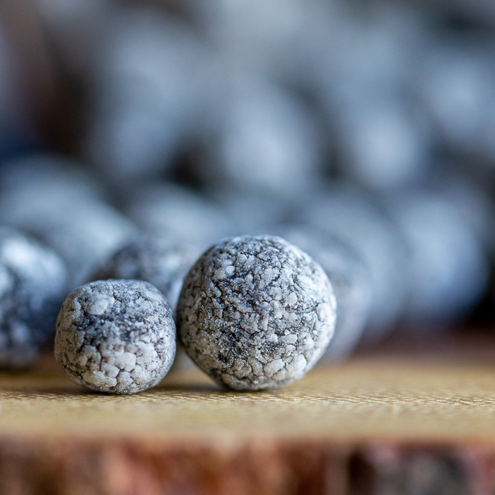 super close up shot of boba balls uncooked with the cassava starch on top to prevent them from sticking to each other.