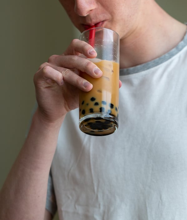 Young adult drinking and enjoying a Homemade Cream Earl Grey Bubble Tea.