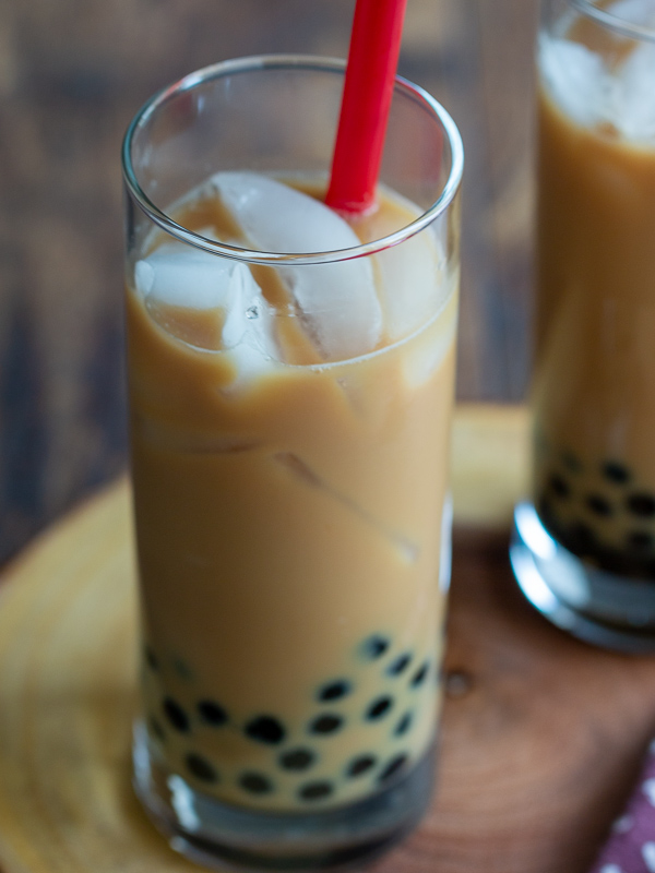 Homemade Cream Earl Grey bubble Tea with lots of ice and big red straws.