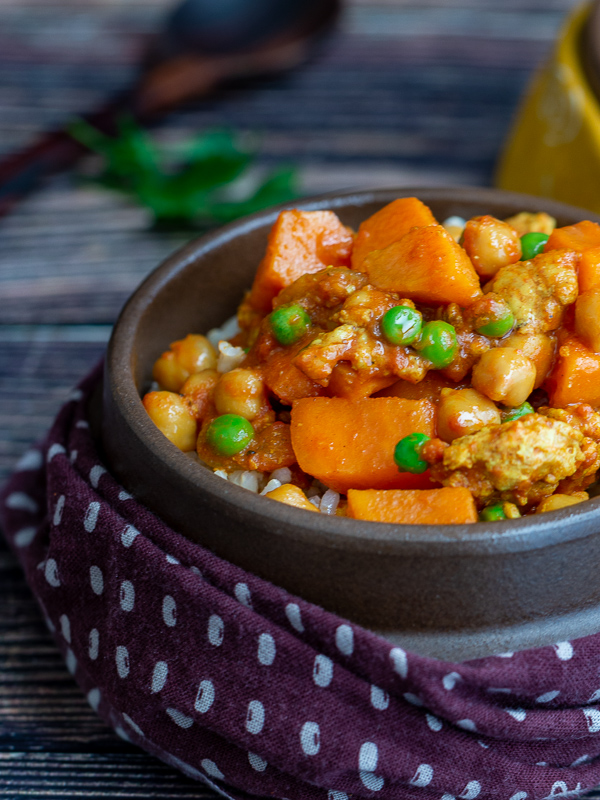 Saucy Ground Turkey Sweet Potato Curry on top of rice in a brown bowl. 