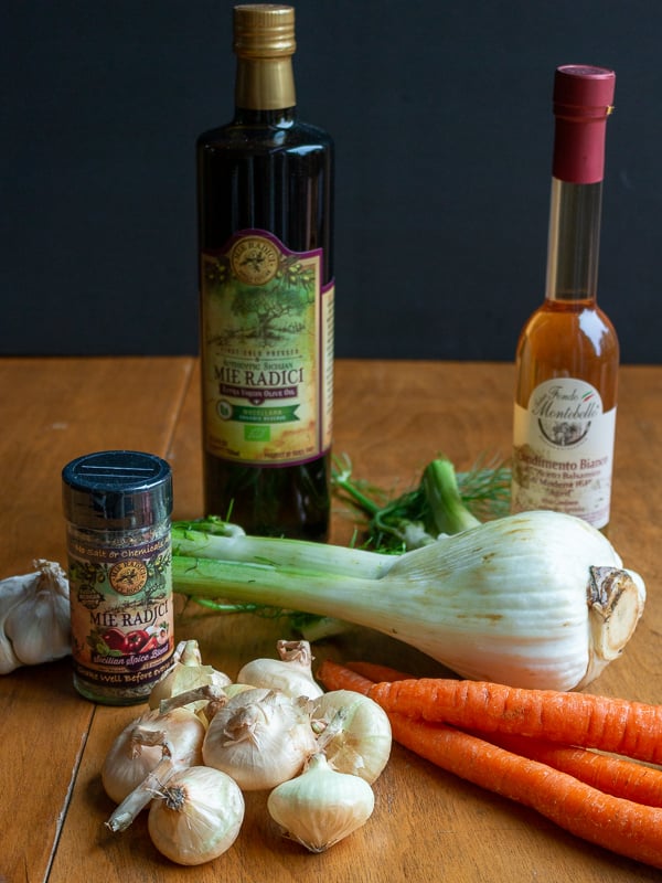 EVOO, white balsamic vinegar and Sicilian spice blend show with raw ingredients.