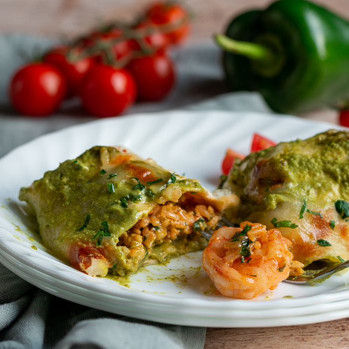 Shrimp Burritos cut in half to show the delicious creamy rice and perfectly cooked shrimp on a white plate. 