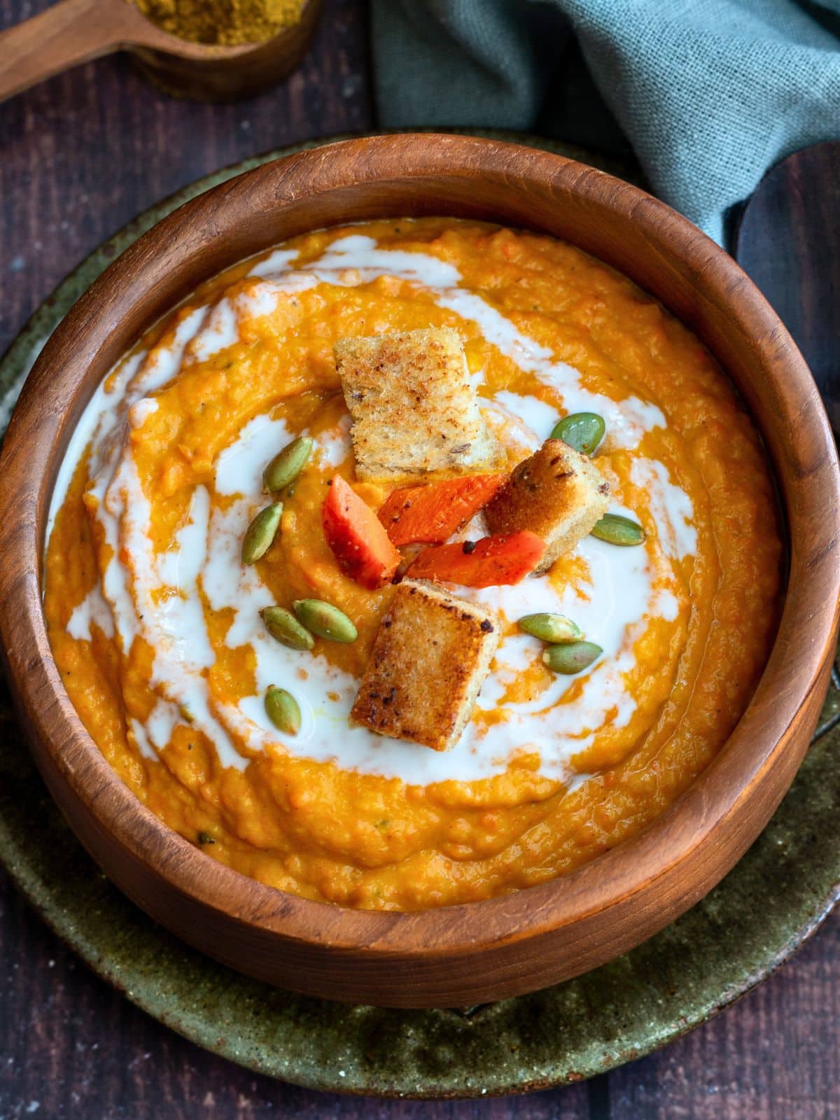 Cozy bowl of thick curried butternut squash soup drizzled with coconut milk.