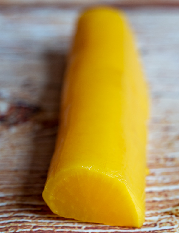 Large bright yellow whole pickled Japanese diakon radish.