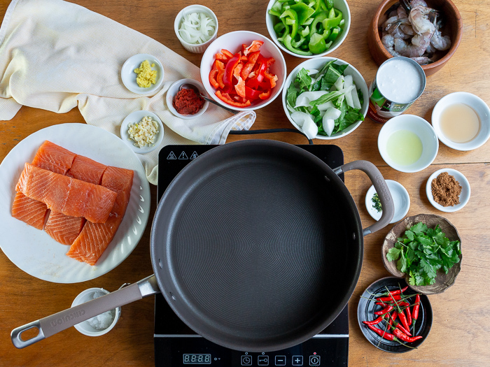 All the Recipe ingredients mise en place around the black pan on top of a burner. 