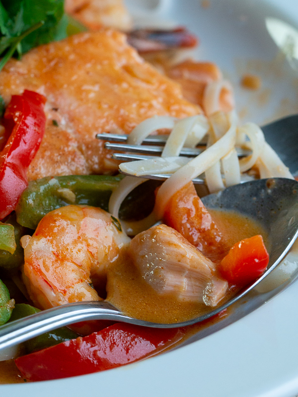 Spoonful of succulent salmon with vegetables and the velvety delicious coconut broth. 