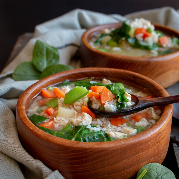 Immune Boosting Chicken and rice soup with veggies in a wooden bowl. 