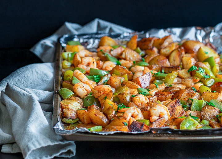 Just out of the oven in the sheet pan are crispy potatoes, shrimp and peppers. 