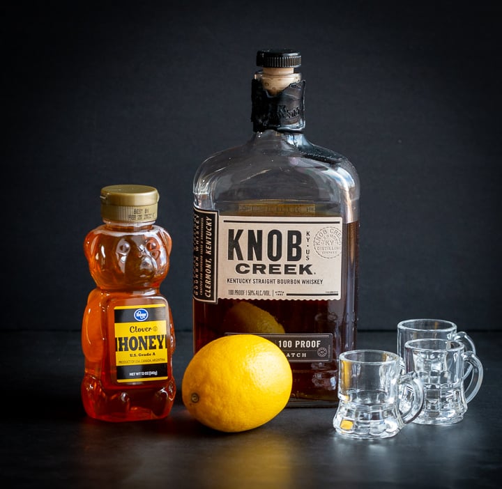Bottle of Knob Creek Whiskey, little bear honey and a whole lemon. 