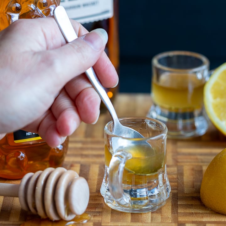 Stirring the Whiskey Honey Lemon Cough Syrup in the shot glass. 