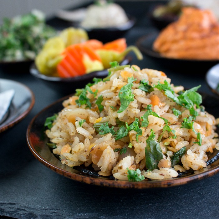 Middle Eastern Rice and Lentils on a black plate garnished with parsley.