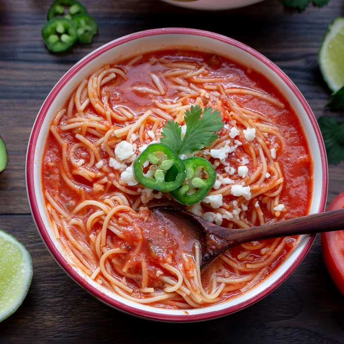 Mexican Noodle Soup garnished with cheese and cilantro. 