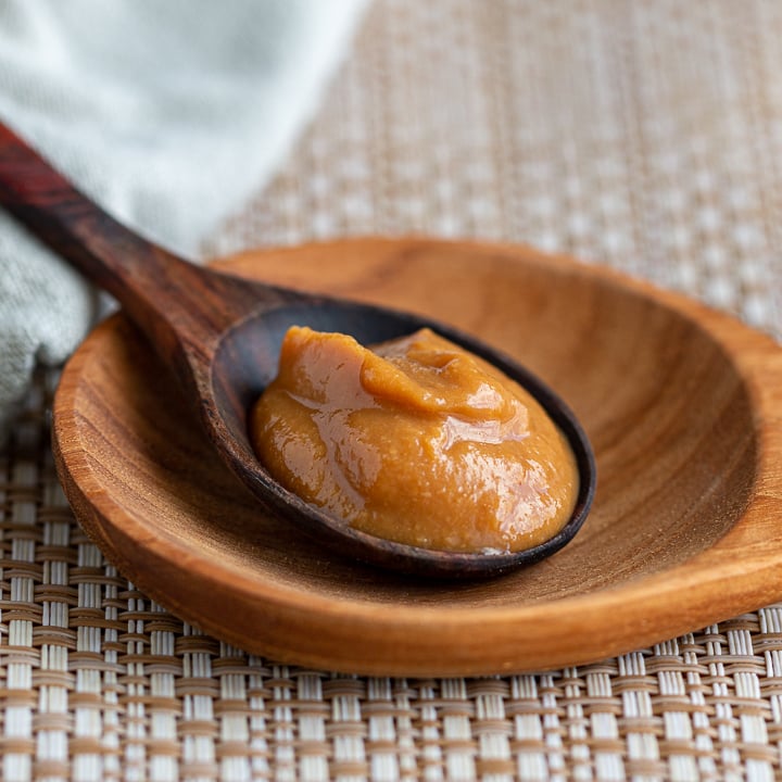 A spoonful of miso paste on a wooden bowl.