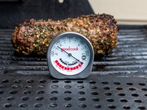 Cooke leg of lamb with a meat thermometer showing medium rare.