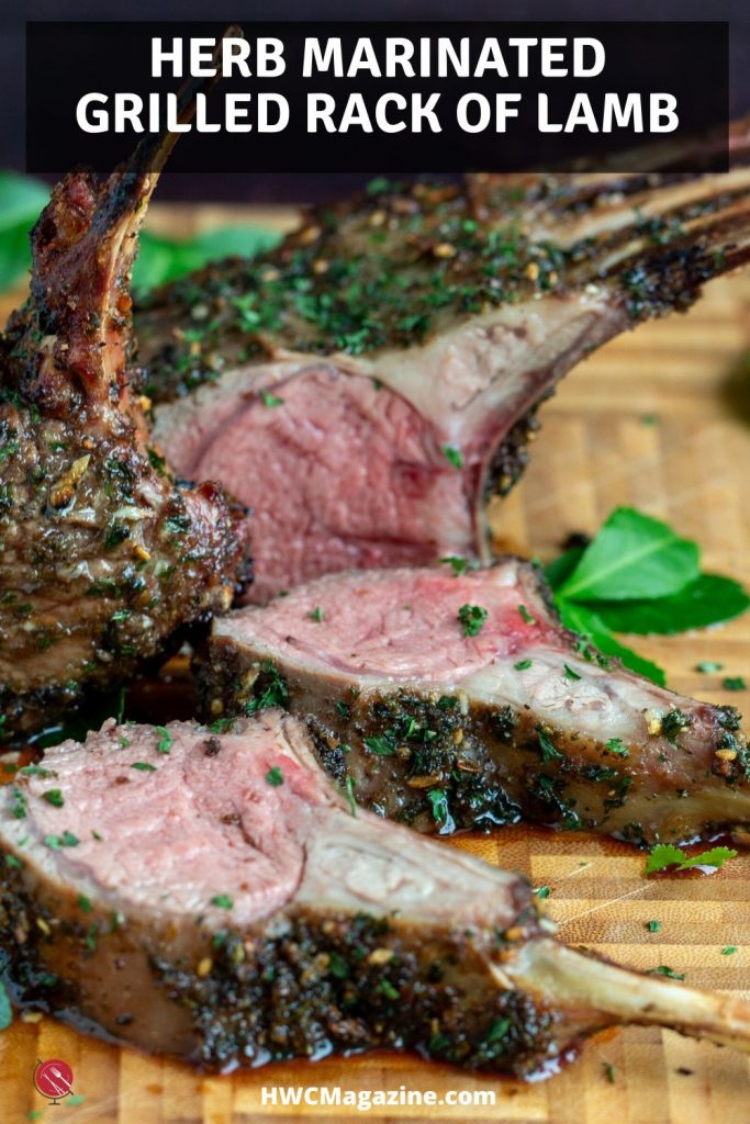 Whole Herb Marinated Grilled Rack of Lamb cut into slices on a cutting board with fresh herbs.