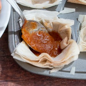 Apricot jam filling getting placed into the prepared phyllo pastry dough cups.