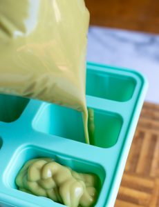 Avocado mixture getting piped into popsicle molds.