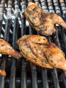 Cornish hens grilling skin side up after getting flipped.