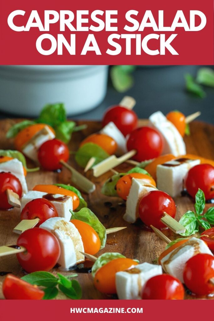 Caprese Salad on a stick drizzled with balsamic glaze on a wooden plate.