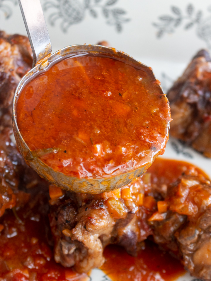 Red wine tomato sauce in a ladle.