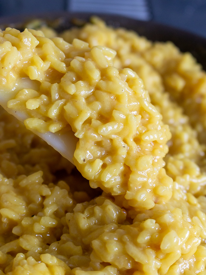 Risotto getting stirred in the pan.