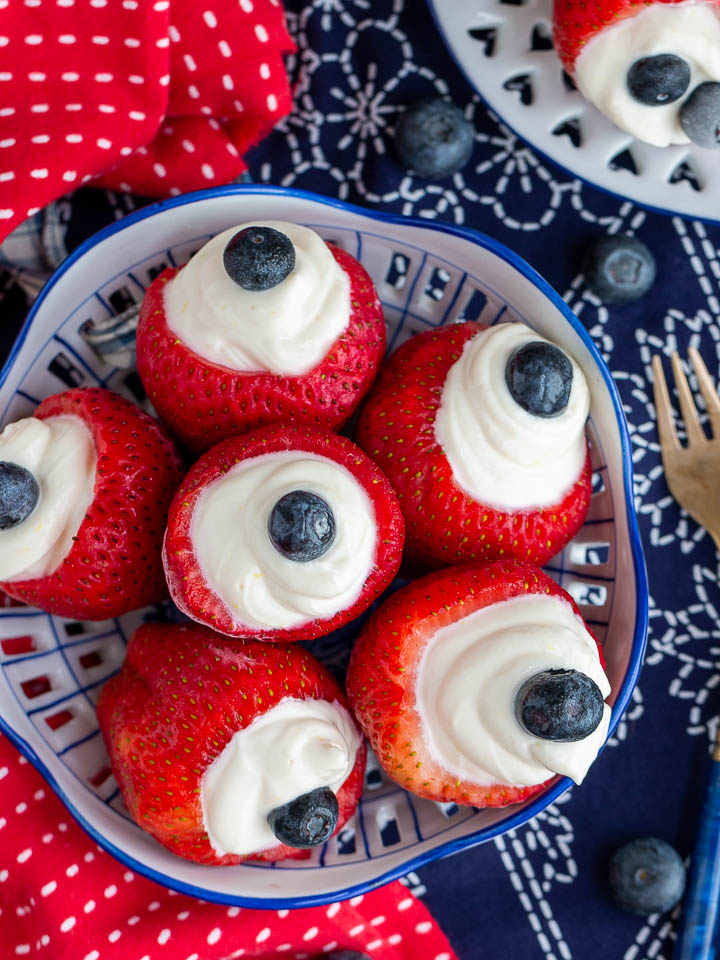 Cheesecake stuffed strawberries on a old fashion white and blue plate.