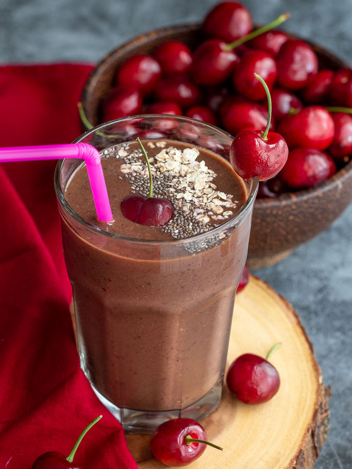 Big  bowl of red cherries with a Mexican Chocolate cherry smoothie ready to drink..