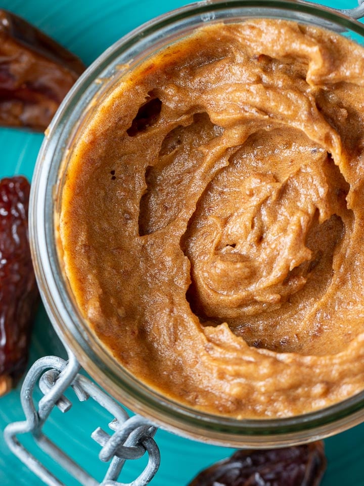 Close up shot of Medjool date paste in a glass canning container.