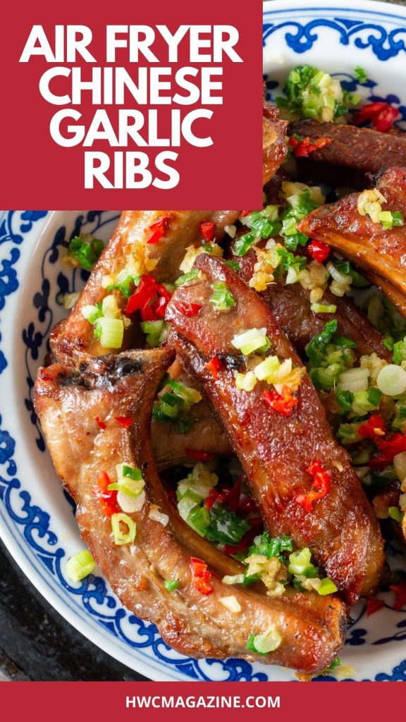 Golden brown ribs with fried garlic and chilis in a blue and white plate.