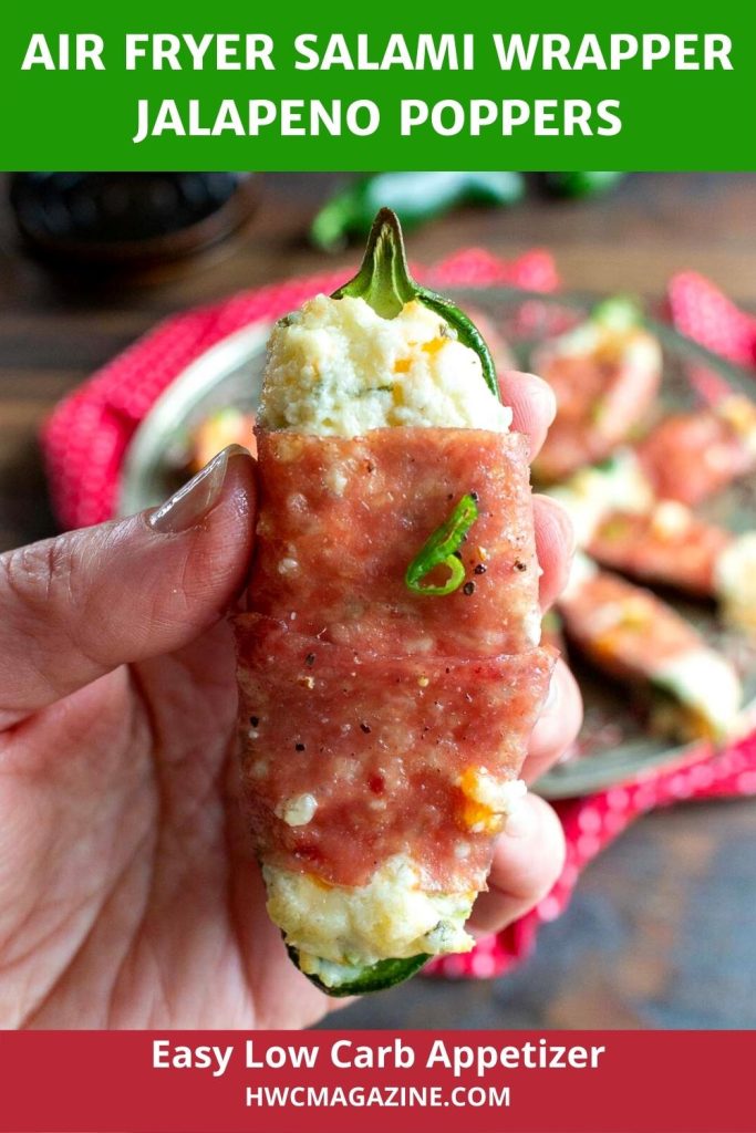 Holding a jalapeno popper up close so you can see the crispy salami and cheesy filling.