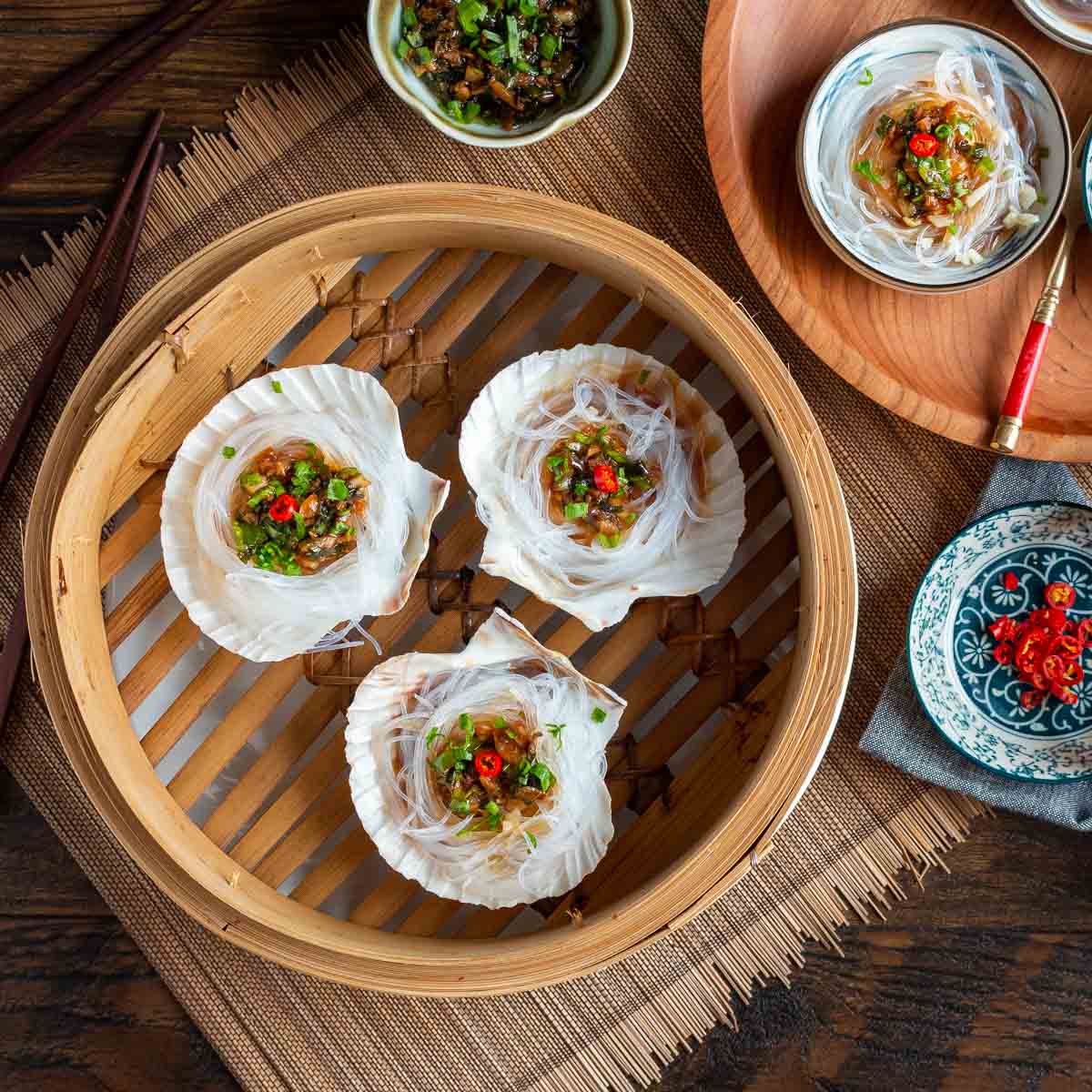 Asian Steamed Scallops with Garlic Vermicelli glass noodles in a Chinese steamer basket.