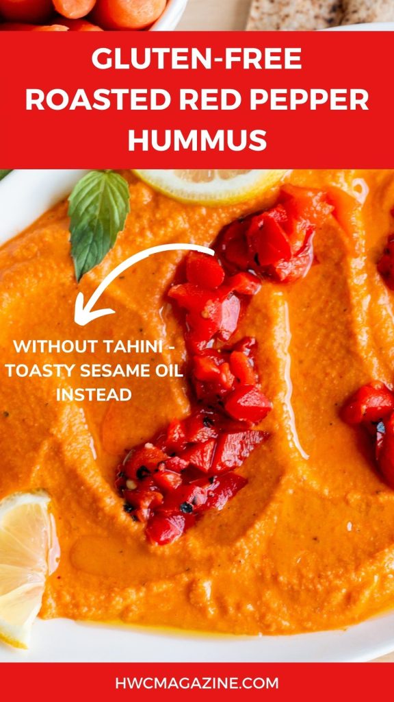 Close up shot of roasted red pepper hummus with a sign made without tahini but sesame oil instead.