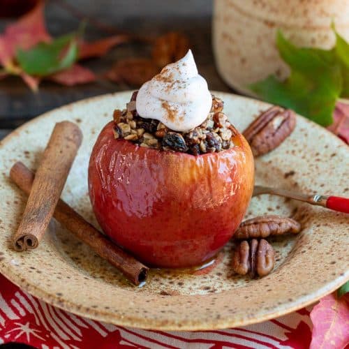 Air fryer baked apples stuffed with a date pecan filling and topped with coconut whipped topping.