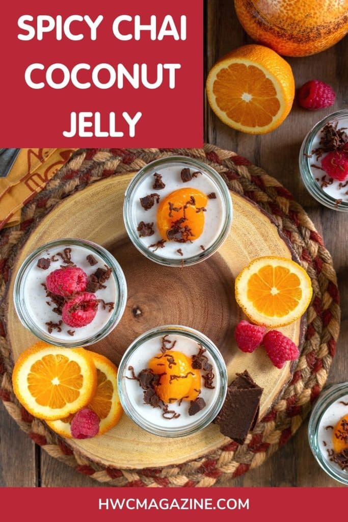 Spicy chai coconut jelly jars on a wooden board and garnished with oranges, raspberries and chocolate.